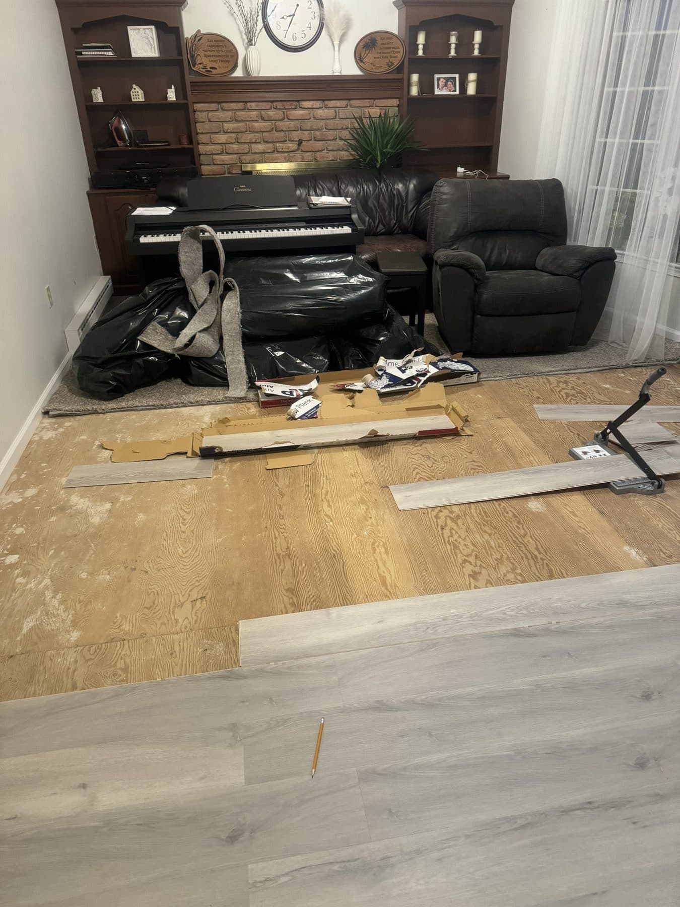 LVP flooring installation in progress, furniture moved aside