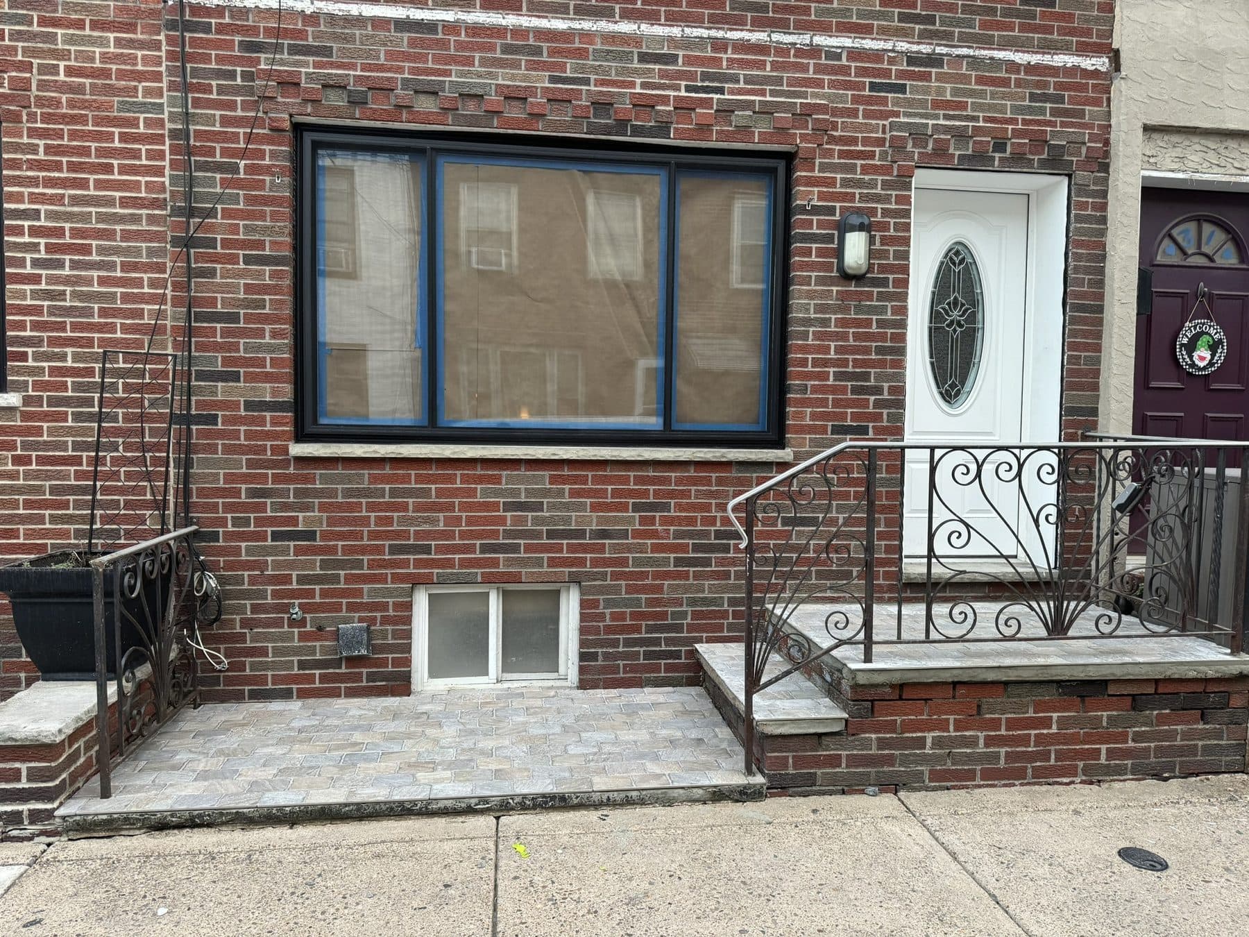 Rowhome front after: black windows, new entry door and iron railings