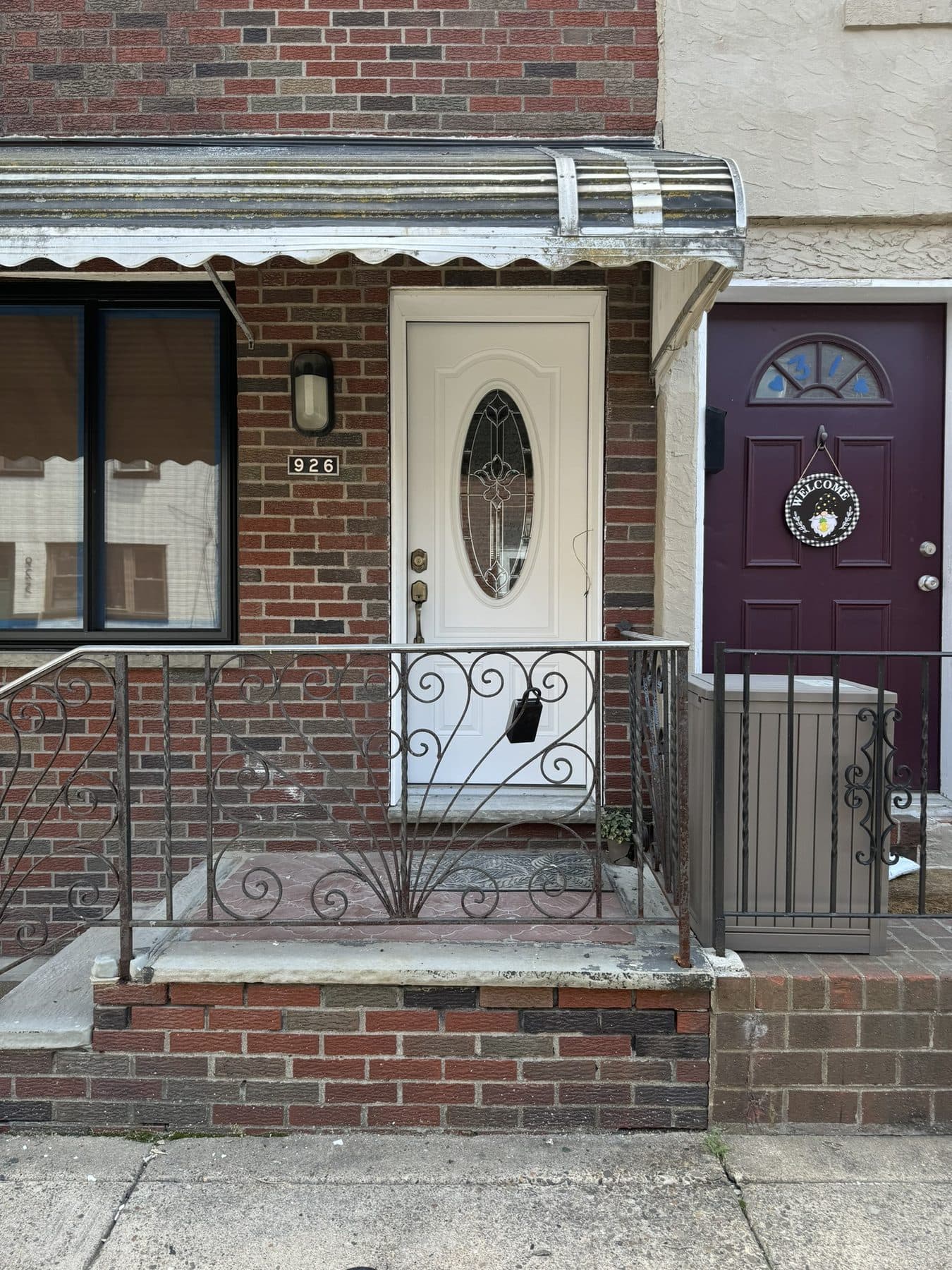 Rowhome front before: old awning, old door and worn railings