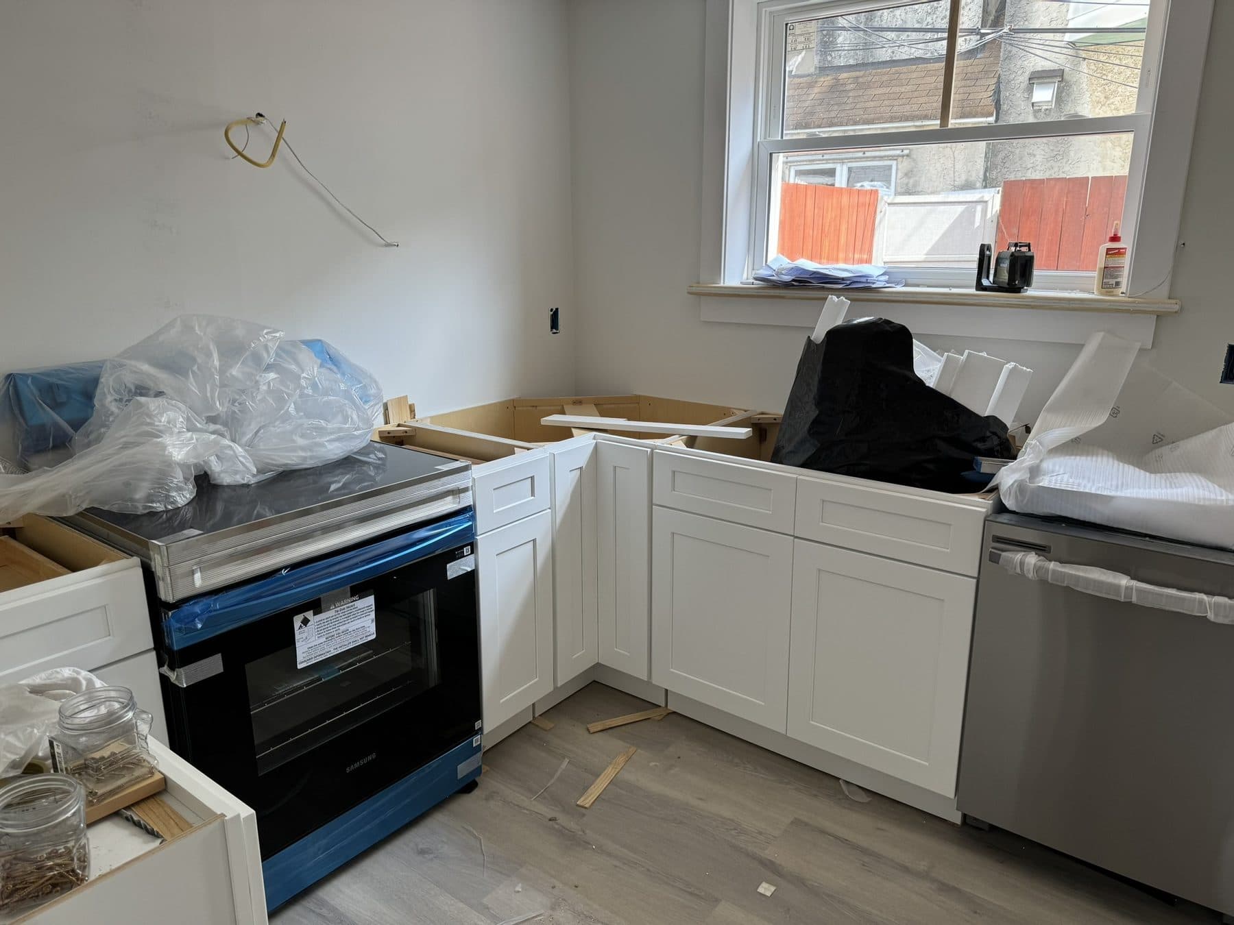 Kitchen cabinets being installed, appliances still wrapped, South Philadelphia