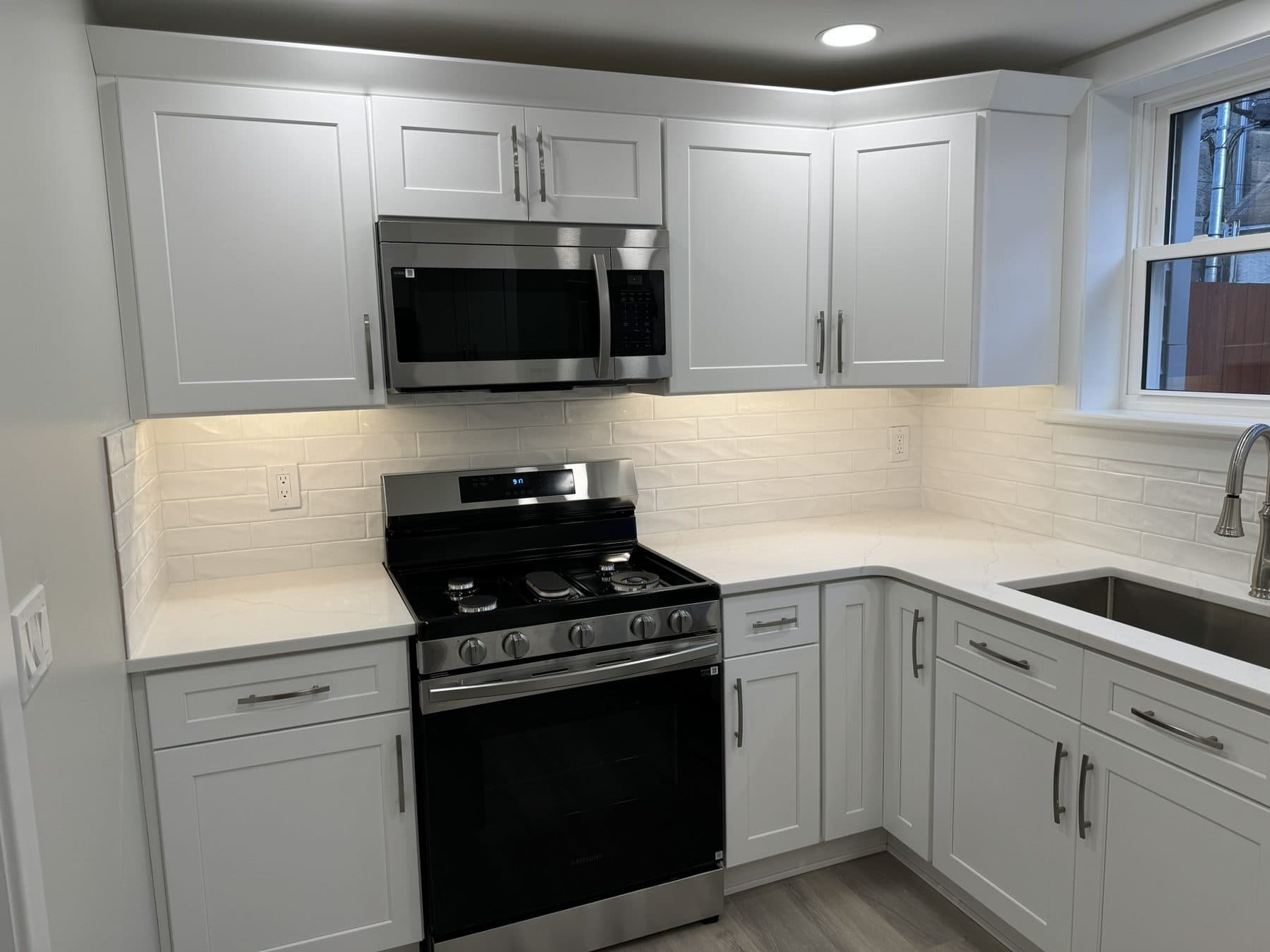 Finished kitchen with white shaker cabinets, quartz counters and stainless appliances in a South Philadelphia rowhome