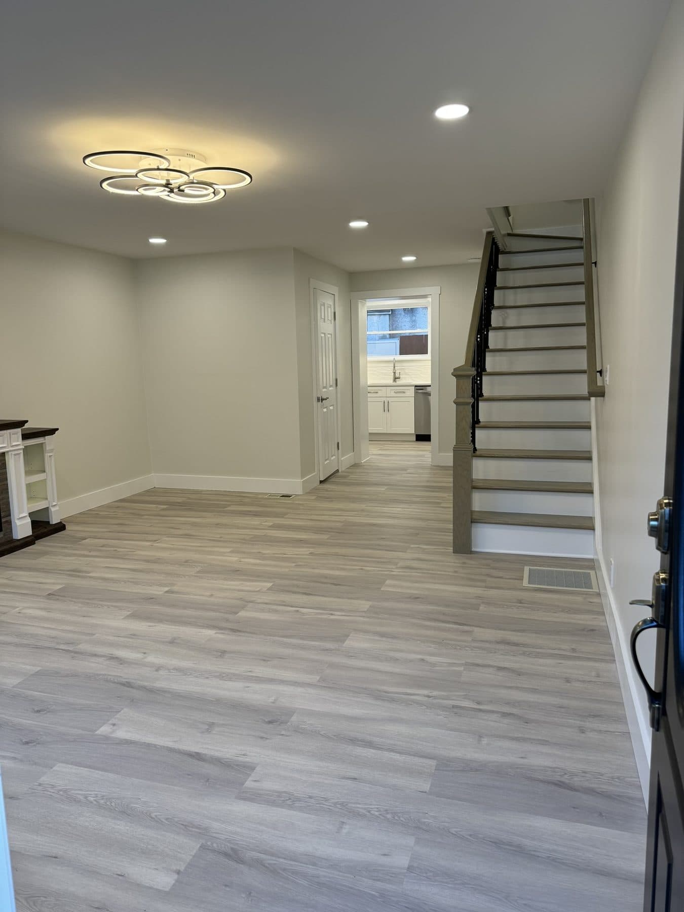 Open first floor with LVP flooring, electric fireplace and new staircase