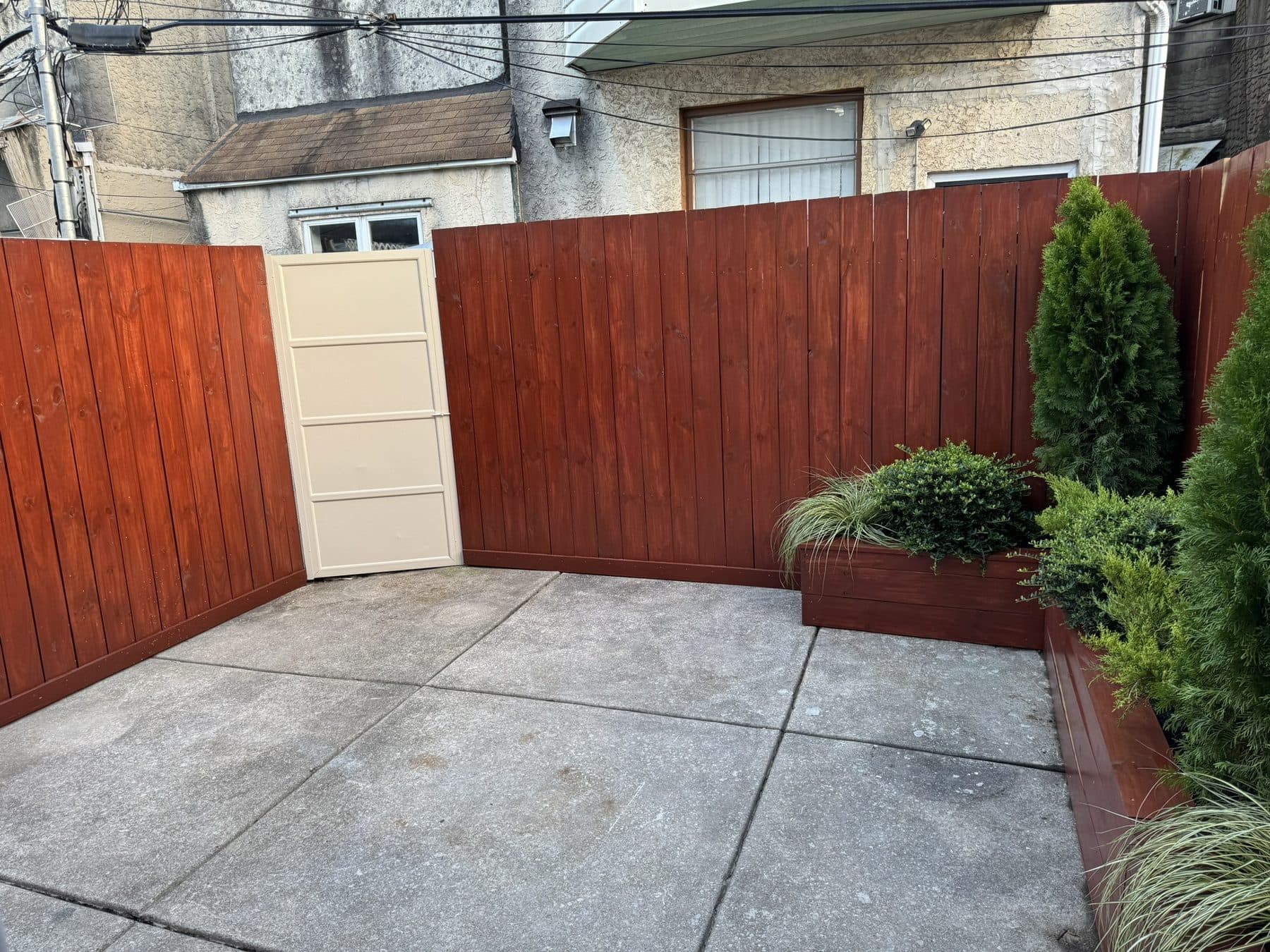 Back patio with new cedar fence, stained planter and plantings